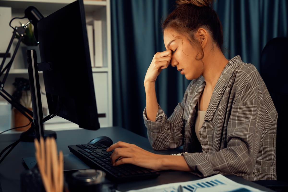 Businesswoman working on computer with stretching arm up at night. Infobahn.